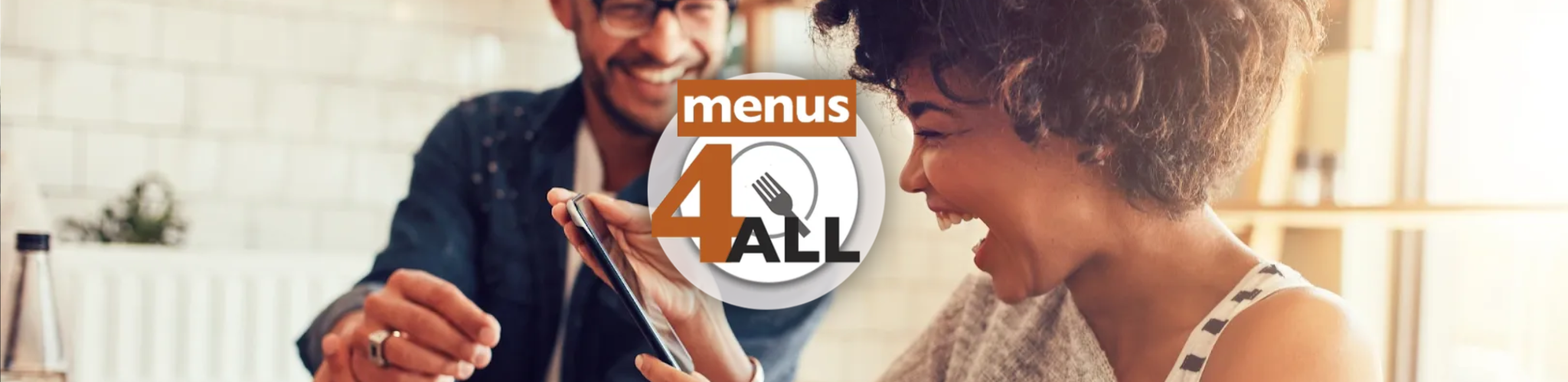 Young couple in restaurant with lady delighted with her phone. Menus 4 ALL logo